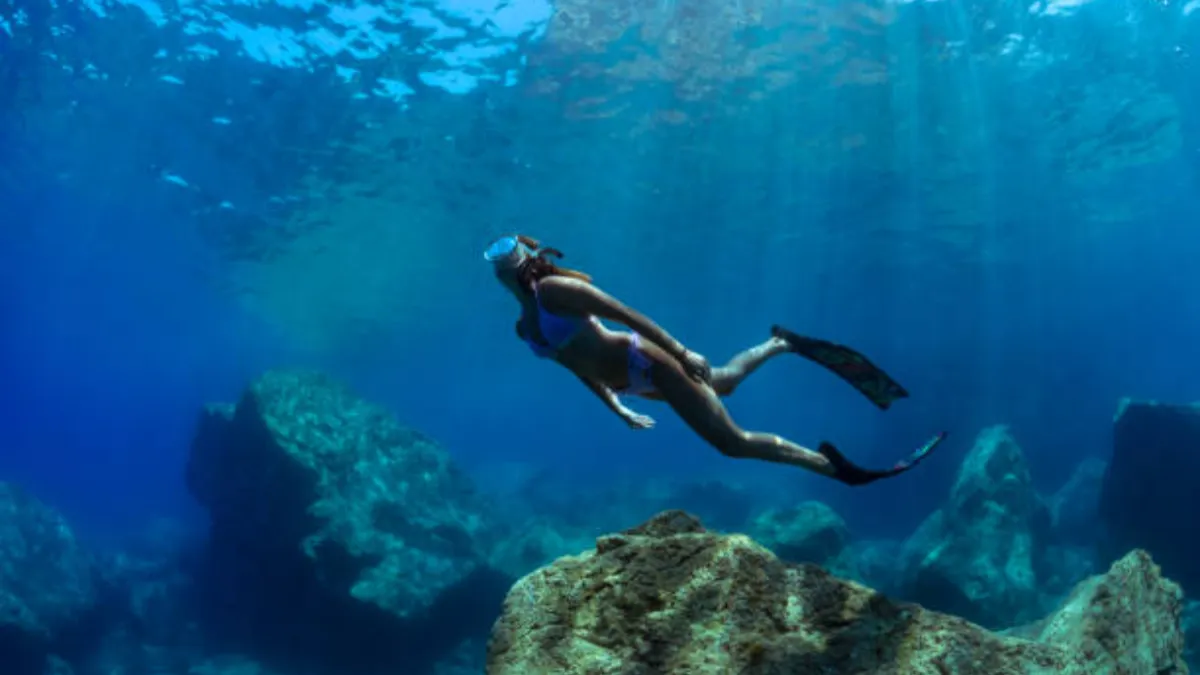 Freediver descending on a single breath wearing long-blade carbon freediving fins