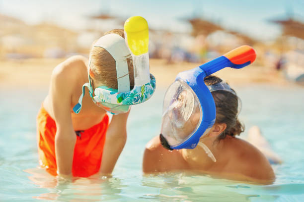 Picture of the mother and son in water with snorkeling mask.